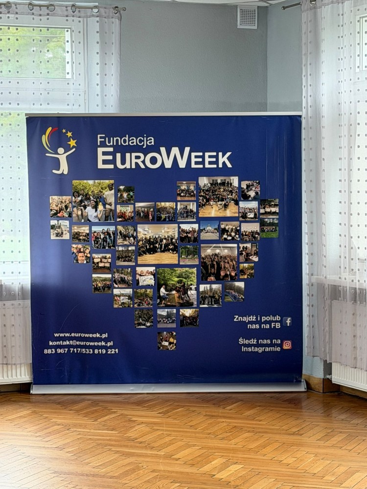 Zdjęcie przedstawia planszę promującą program Fundacji EuroWeek wraz ze zdjęciami uczestników
