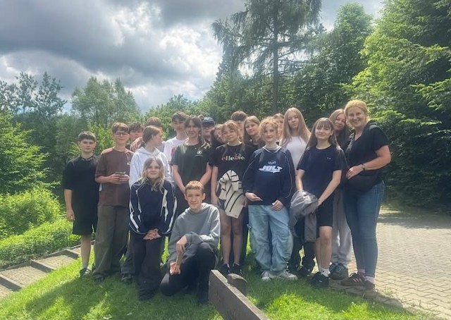 Zdjęcie przedstawia uczniów klasy 6b podczas zajęć w Lesnym Ośrodku Edukacji Ekologicznej.