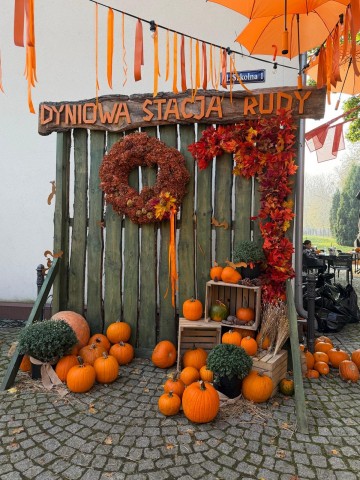 Zdjęcie przedstawia jesienną dekorację przy wejściu na teren Zabytkowej Stacji Kolei Wąskotorowej w Rudach, przygotowaną z okazji Święta Pieczonego Ziemniaka.